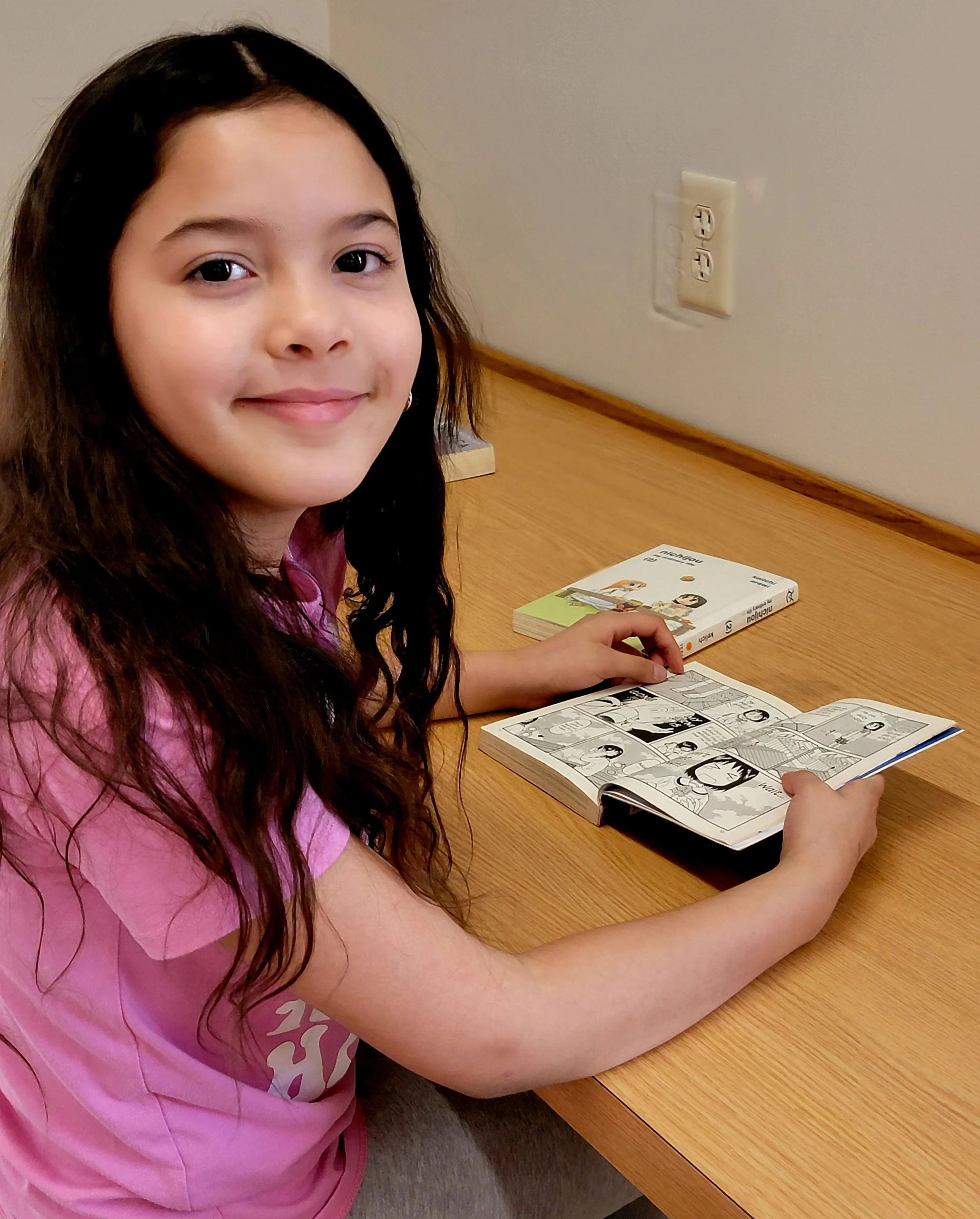 girl smiling while reading a graphic novel